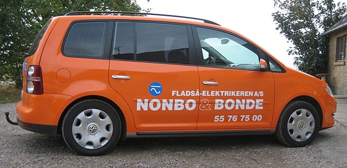 Orange firmabil med hvid skrift på siden holder parkeret